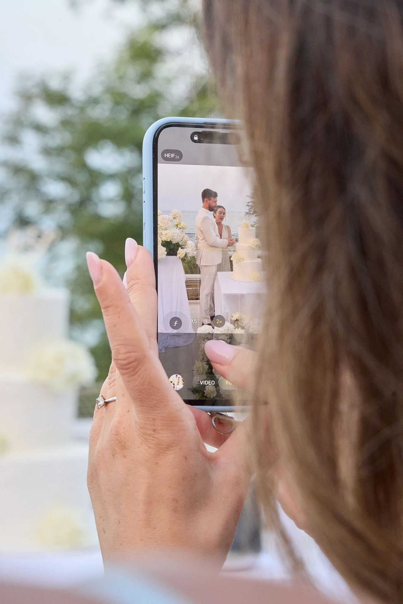 Il taglio della torta ripreso da uno smartphone durante un matrimonio a Terrazza Setterose